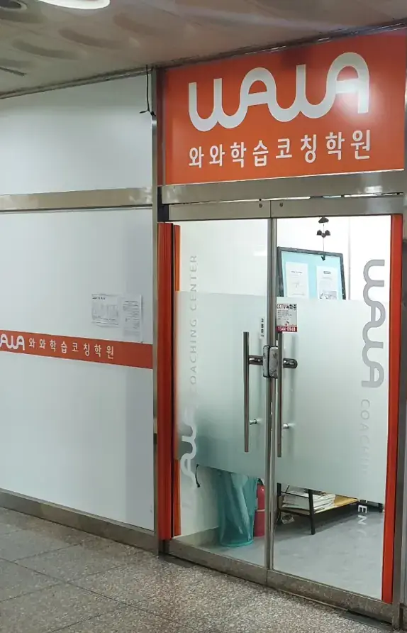 주황색 와와 간판 아래 반투명 유리문이 있는 호매실점 출입구